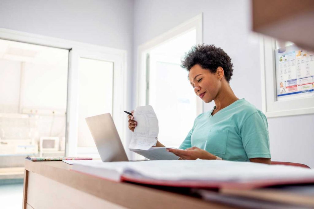 woman sitting at table looking at papers