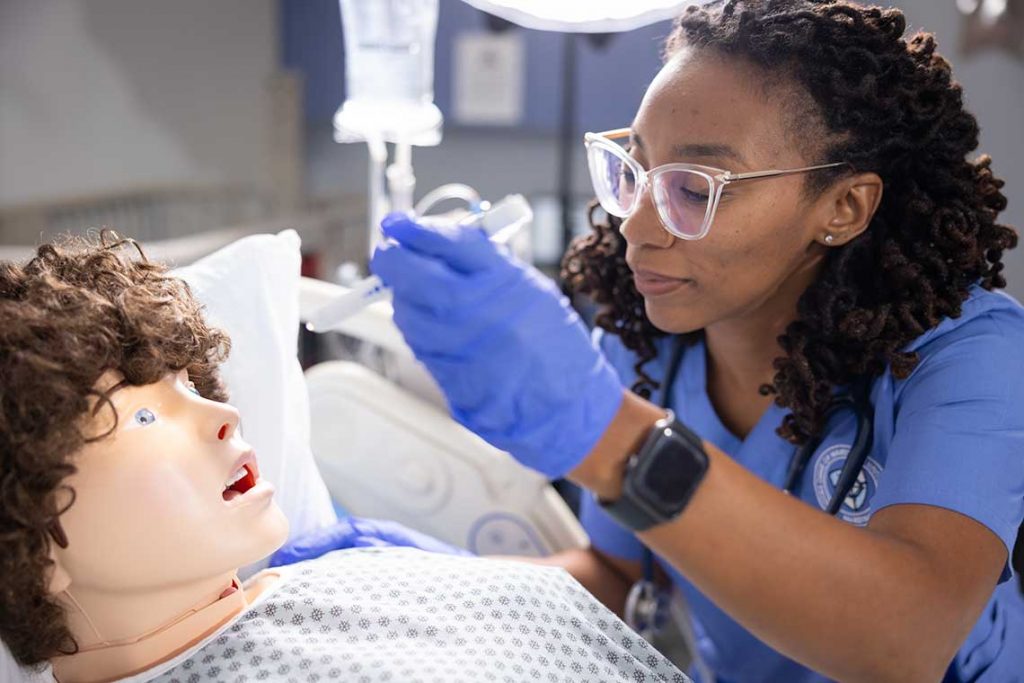 nursing student working with sim manikin